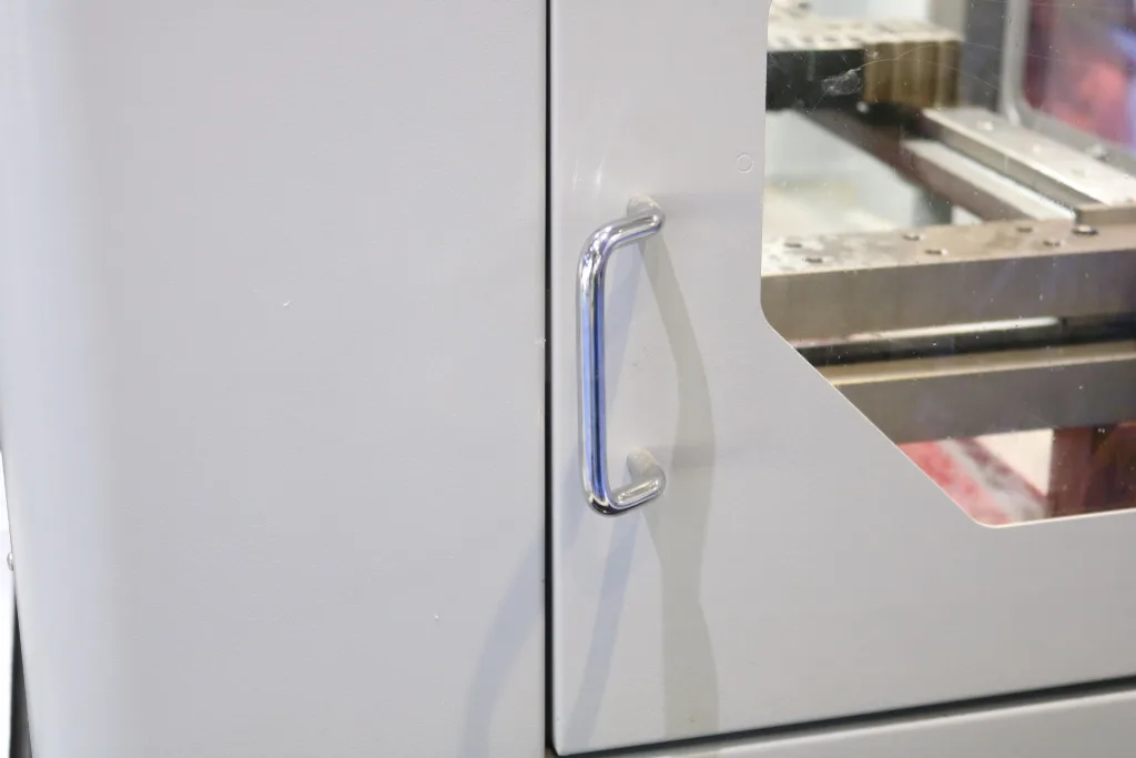 Puxador em aço inoxidável instalado na porta do invólucro de um equipamento industrial