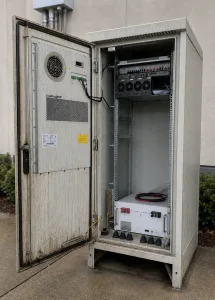 Outdoor electrical enclosure with water marks, gasket aging, and latch area showing early seal loss